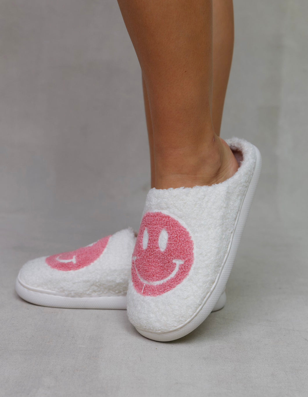White slippers with pink smiley face